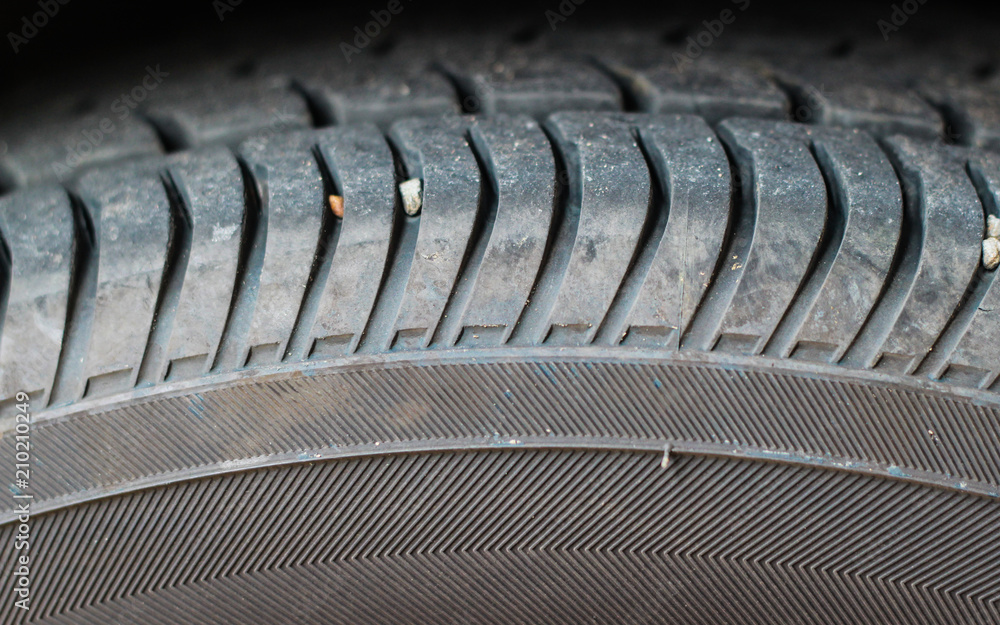 Tire wear concept. Danger of using old car bald tire with very little tread remaining.