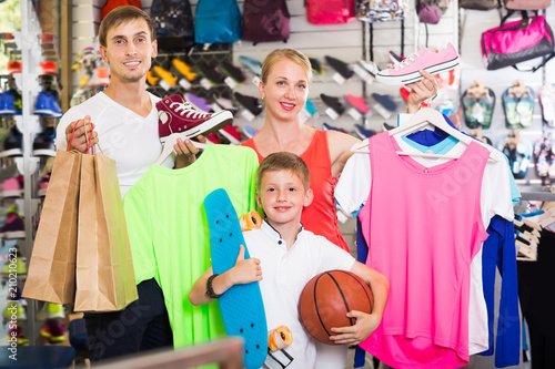 Glad parents with boy in sport store