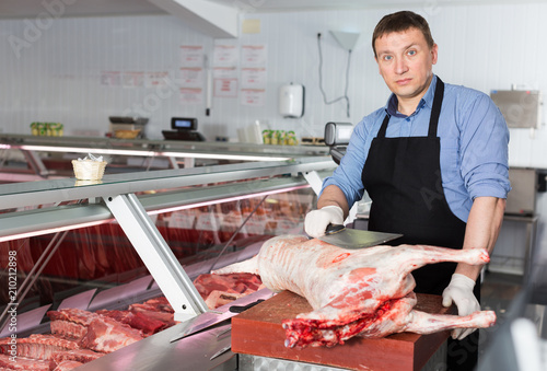 Butcher processing carcase of lamb