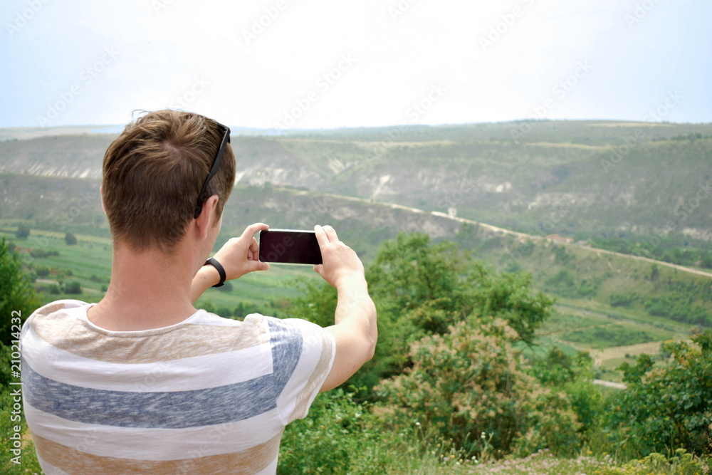 Young man making mobile photo of landscape Young man making mobile photo of landscape