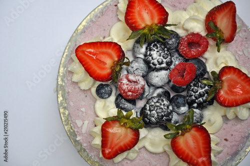 Pink cake topped with fresh summer berries