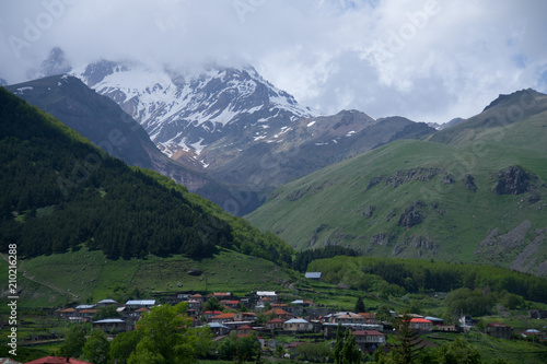 View of mountain Kazbegi with snow on top and village Stepantsminda in valley