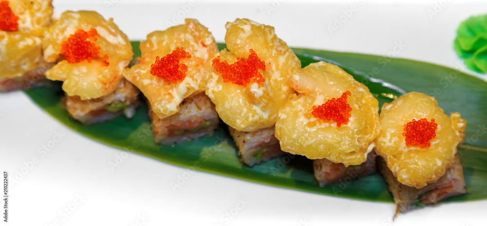 В японском ресторане роллы с креветками темпура, соусом, c  лососем, авокадо, на банановом листе, имбирем, васаби. 