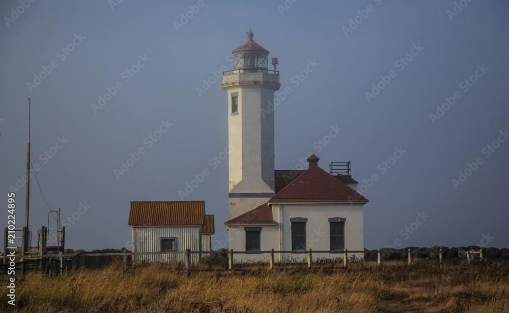 Lighthouse and buildings on misty day