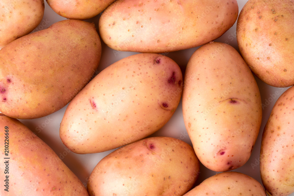 Raw young potatoes on a white background, close-up. Raw young potatoes on a white background, close-up.