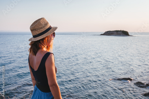 Young woman enjoying sunset on a cliff at a seaside © marjan4782