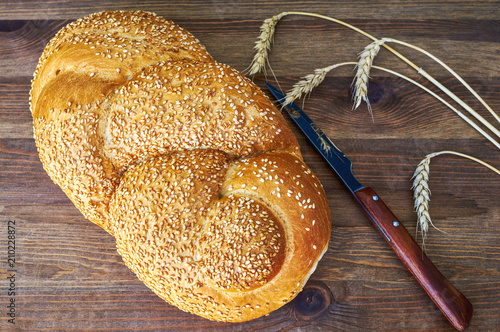 Bread, rye and a knife on a wooden table photo