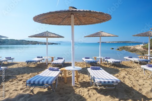 Umbrellas with sunbeds on beautiful sandy Santa Maria beach with turquoise sea water, Paros island, Greece © Mazur Travel