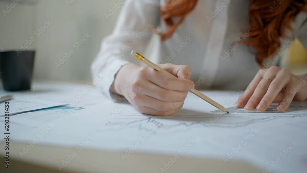 Hands of young female financial analytic drawing lines with pensil and ...