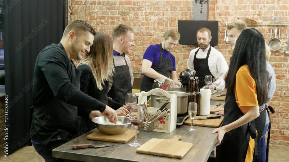 A group of people talking, laughing, preparing a food at cooking master class. 4K A group of people talking, laughing, preparing a food at cooking master class. 4K