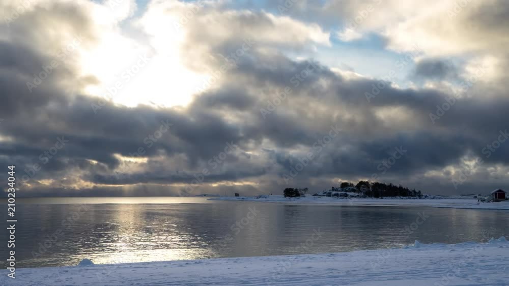 Timelapse of clouds passing over bay and snow covered beach in winter Timelapse of clouds passing over bay and snow covered beach in winter