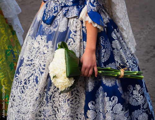 detalle de traje de fallera bordado a mano y ramo de flores que se utiliza para realizar la ofrenda a la Virgen de los Desamparados, en la fiesta de Las Fallas, Valencia, España photo