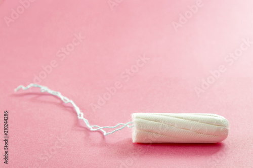 Menstrual cycle, feminine care, menstruation and intimate products concept with internal tampon isolated on pink background with copy space