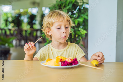 portrait of smiling little boy looking at camera during breakfast on the terrace photo