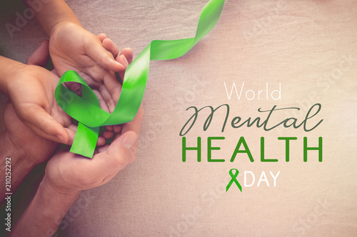 Fototapeta Naklejka Na Ścianę i Meble -  Adult and child hands holding Lime GreenRibbon, world Mental health day
