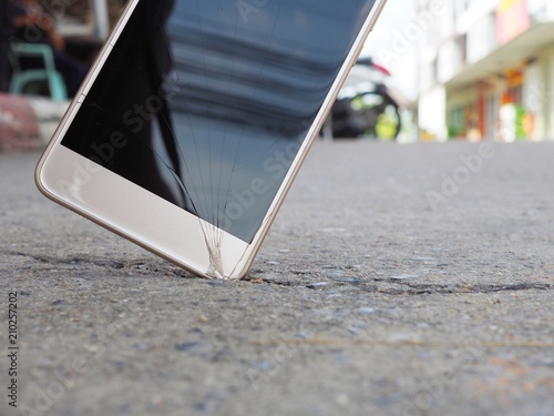 Smartphones drop to the ground. Make the screen broken and damaged.Background image blur With the concept of accident insurance technology, repair and maintenance. Event over expected data retention.