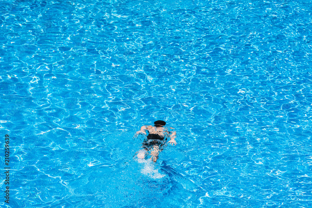 Children diving in a pool in summer