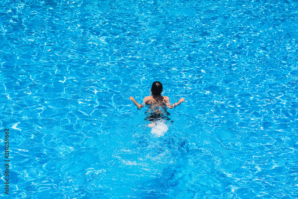 Children diving in a pool in summer