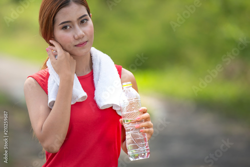 Young woman drinking water after exercise. photo