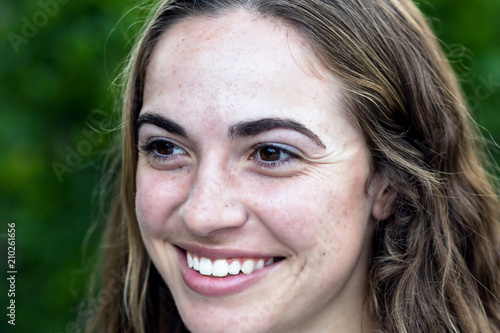 Portrait of young woman outside smiling in natural light
