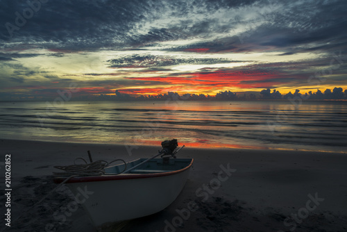A beautiful dawn on a topical beach with a boat