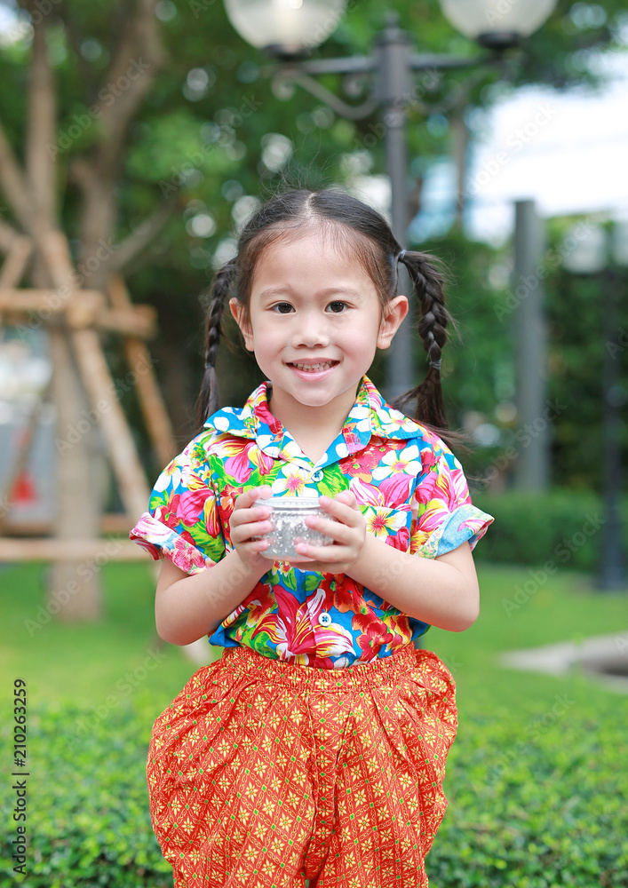Happy little Asian thai children in thai period dress holding bowl of water to playing in songkran festival (Thai new year - water festival). Happy little Asian thai children in thai period dress holding bowl of water to playing in songkran festival (Thai new year - water festival).