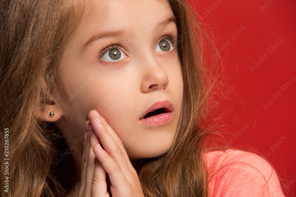 Beautiful teen girl looking suprised isolated on red Beautiful teen girl looking suprised isolated on red