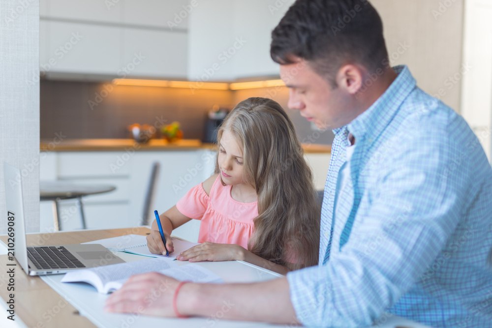 Young dad with a little daughter doing homework Young dad with a little daughter doing homework