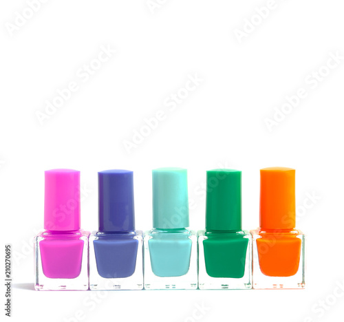 group of colorful nail polish bottles on spilled paint