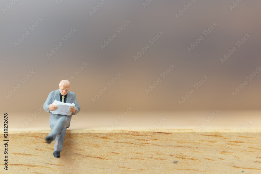 Miniature people Thinking about next great idea on wooden background