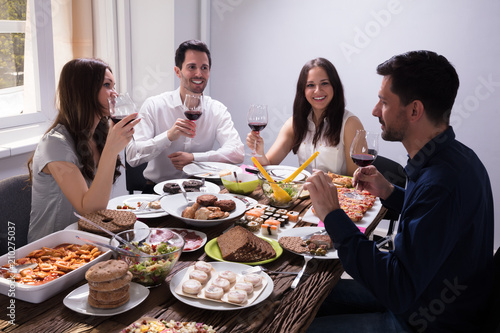 Friends Enjoying Food With Glass Of Wine