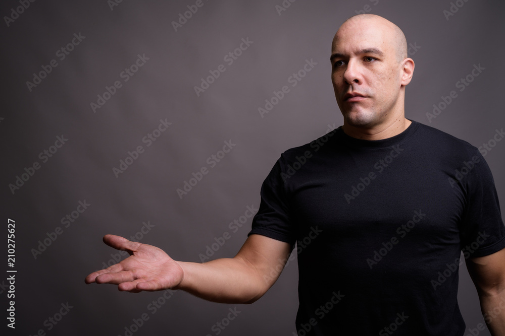 Handsome bald man against gray background Handsome bald man against gray background