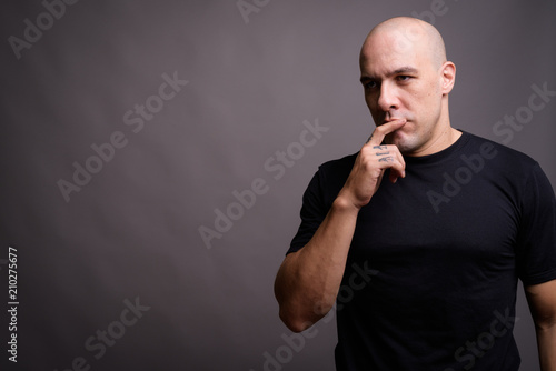 Handsome bald man against gray background © Ranta Images