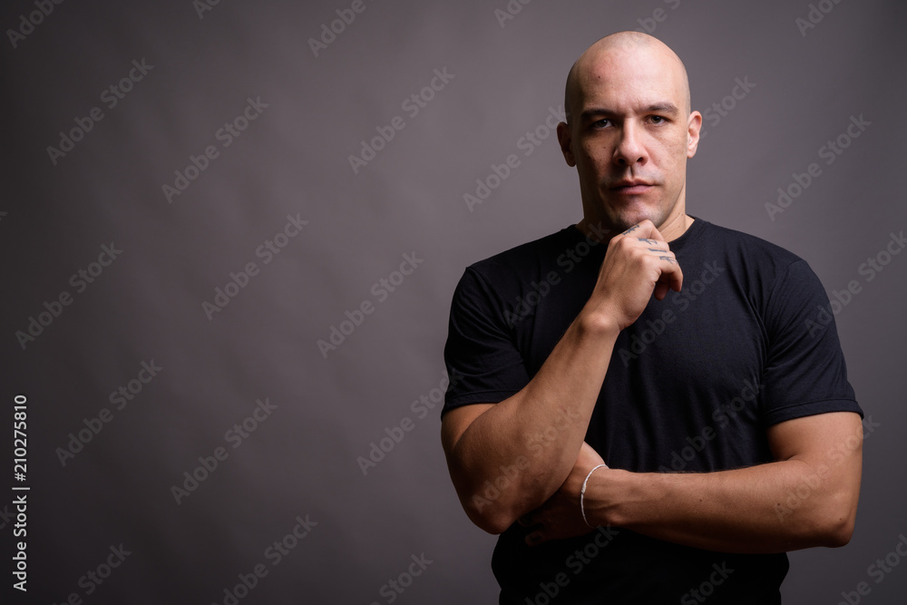 Handsome bald man against gray background Handsome bald man against gray background