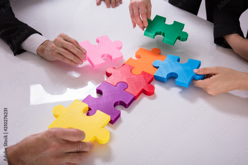 Group Of Businesspeople Solving Jigsaw Puzzle
