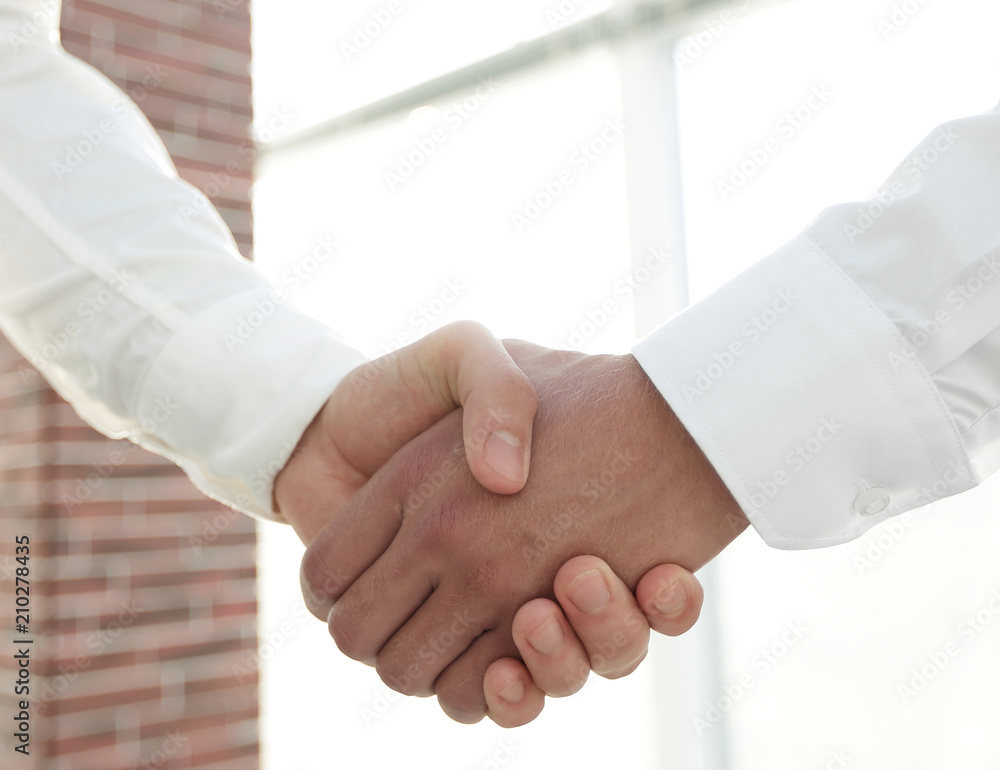 Closeup of a business handshake, on bright background Closeup of a business handshake, on bright background