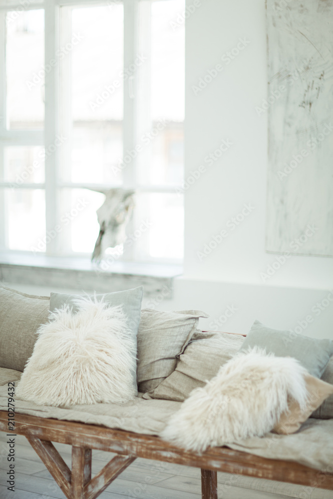 A self-made sofa with light soft pillows in a light-white interior A self-made sofa with light soft pillows in a light-white interior