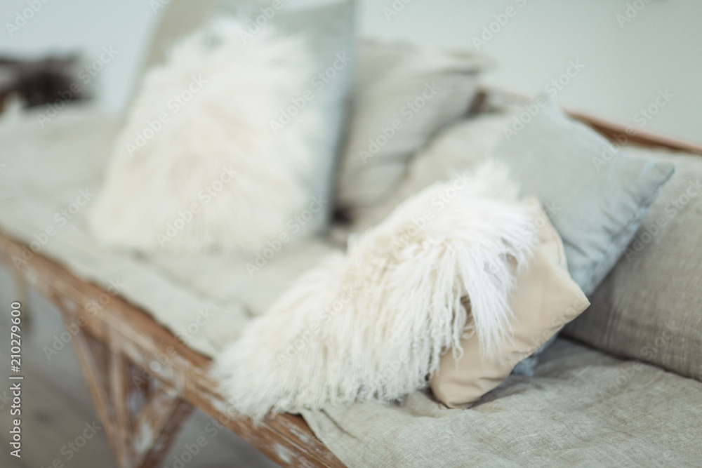 A self-made sofa with light soft pillows in a light-white interior A self-made sofa with light soft pillows in a light-white interior