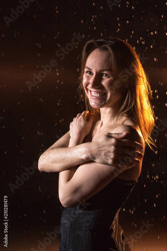Girl in black dress, drops of water and dark background