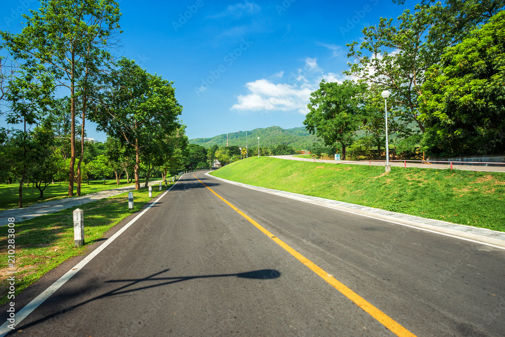 Along road landscape view in Ang Kaew Chiang Mai University Forested Mountain blue sky background with white clouds, Nature Road in mountain forest.