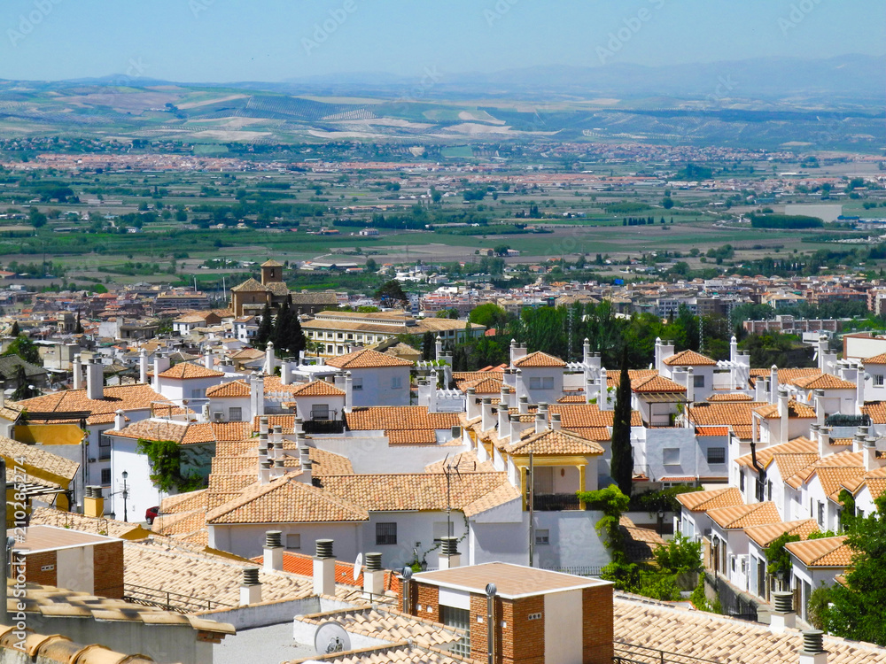 Albaicin, Old muslim quarter, district of Granada in Spain. Houses with orange tiling. Sierra Nevada mountains. View from the top of Sacromonte mountain. Panorama.