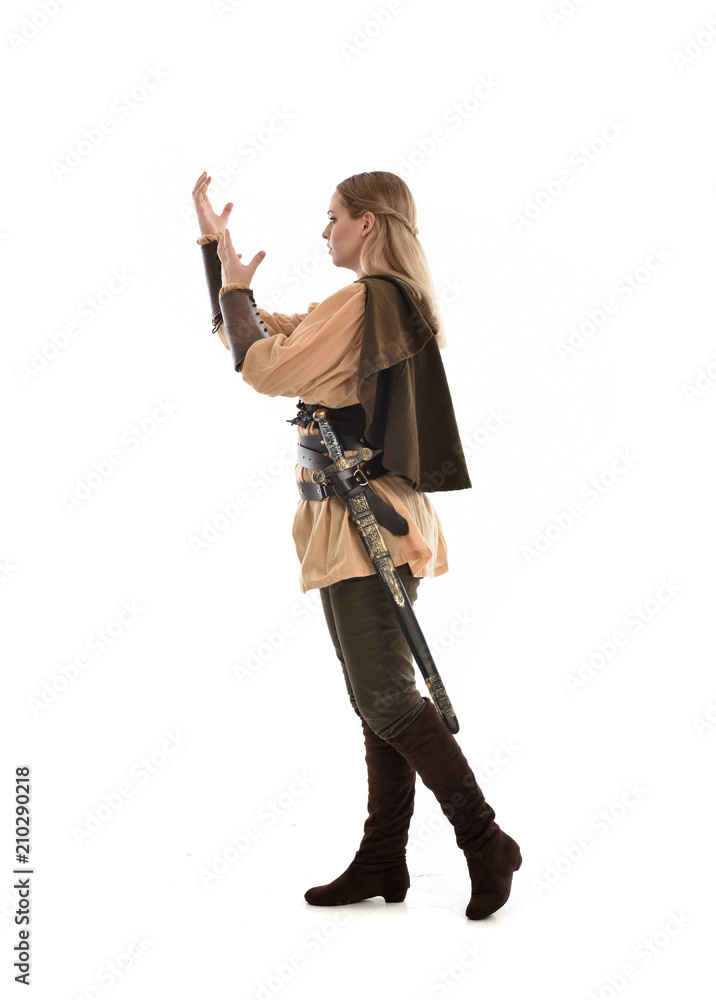 full length portrait of girl wearing medieval costume with sword. standing pose with back to the camera, isolated on white studio background. full length portrait of girl wearing medieval costume with sword. standing pose with back to the camera, isolated on white studio background.
