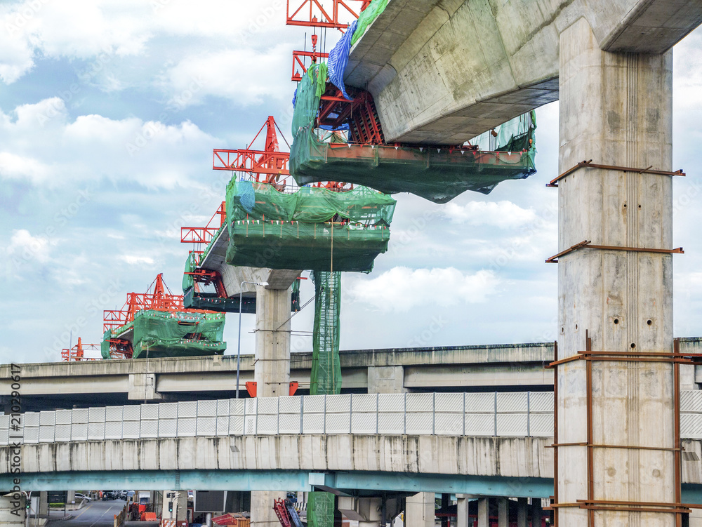 Construction on a high-speed rail bridge With crane in between posts. Urban development