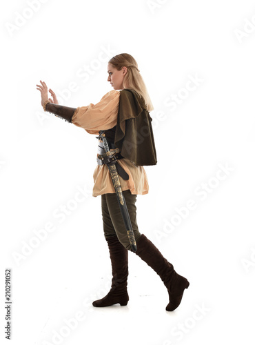 full length portrait of girl wearing medieval costume with sword. standing pose with back to the camera, isolated on white studio background.