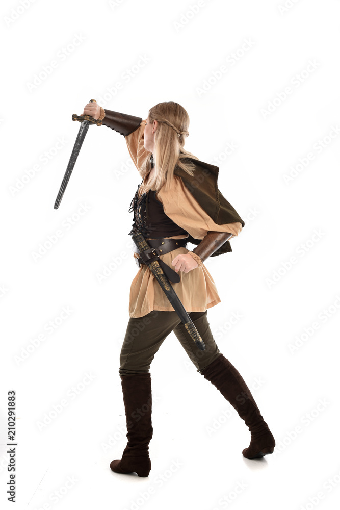 full length portrait of girl wearing medieval costume with sword. standing pose with back to the camera, isolated on white studio background. full length portrait of girl wearing medieval costume with sword. standing pose with back to the camera, isolated on white studio background.