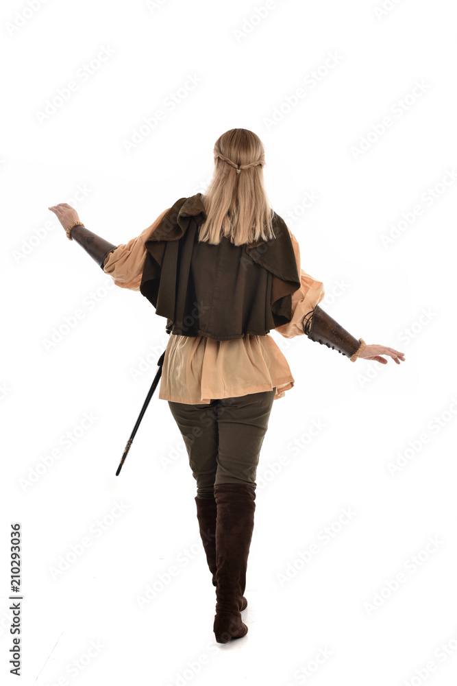 full length portrait of girl wearing medieval costume with sword. standing pose with back to the camera, isolated on white studio background. full length portrait of girl wearing medieval costume with sword. standing pose with back to the camera, isolated on white studio background.