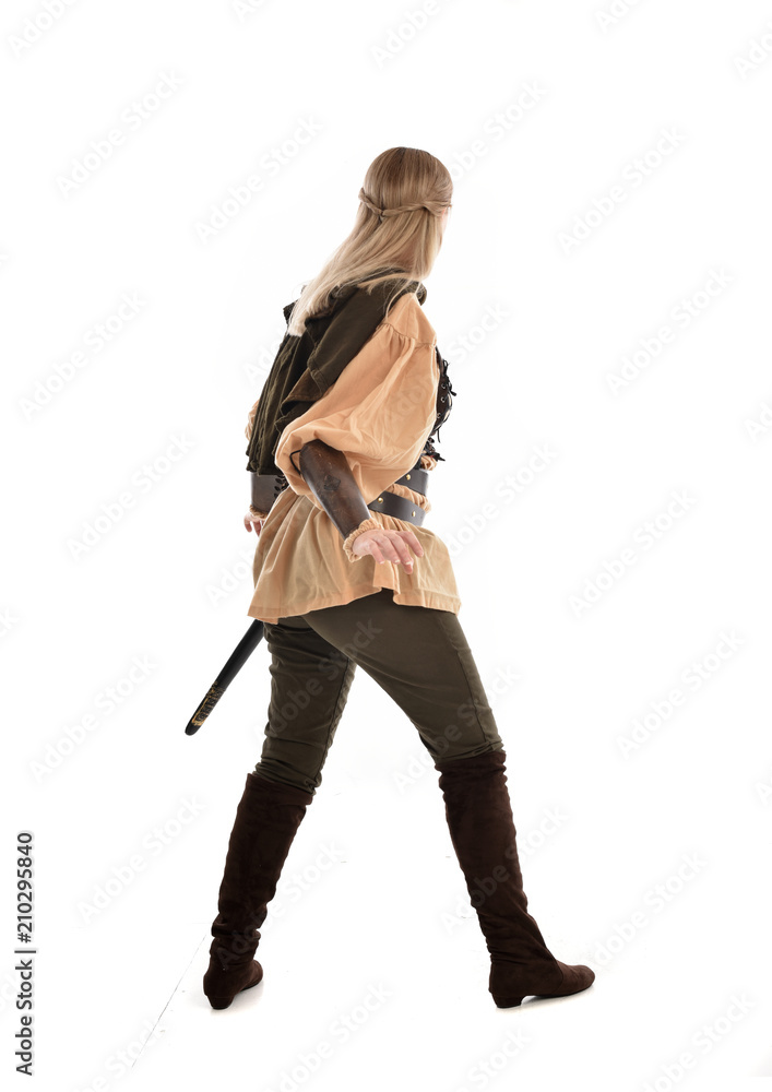 full length portrait of girl wearing medieval costume with sword. standing pose with back to the camera, isolated on white studio background. full length portrait of girl wearing medieval costume with sword. standing pose with back to the camera, isolated on white studio background.