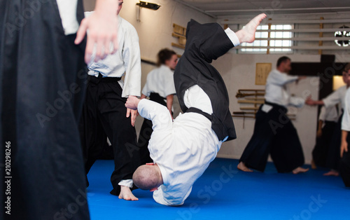 Aikido athletes during training randori. Aikidoka throws the opponent on the tatami photo