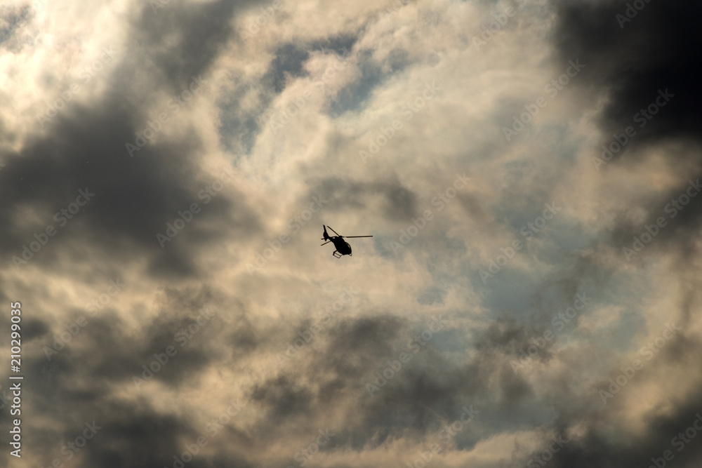 Helicopter, flying in cloudy evening light