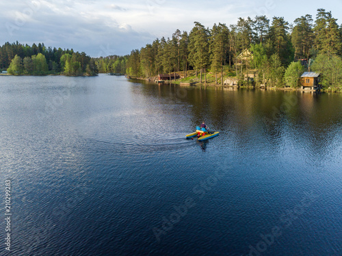 Aerial view of a man who swims on a lake on a pedal catamaran, a water bike